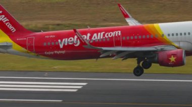 PHUKET, THAILAND - 13 Şubat 2023: Airbus A321, Vietnam Jet Havaalanı 'ndan HS-VKH ve Phuket Havaalanı' na dumanla temas, yan görüş. Sinema filmi geliyor.