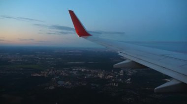 Uçak kanadı. Güzel gün batımı, gökyüzü. Üst Manzara. Pencereden uçak manzarası. Seyahat ediyorum. Yolcu uçağı gün batımında bulutların üzerindedir. Gün doğumu uçuşu. Ticari jet. Pencere deliğinden hava görüntüsü