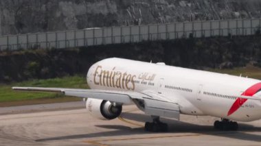 PHUKET, THAILAND - 13 Şubat 2023: Phuket havaalanında taksicilik yapan geniş gövdeli Boeing 777 Emirates uçağı. Jet uçağı geliyor. Turizm ve seyahat kavramı