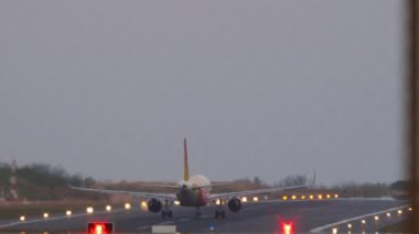 Jet uçağı gün batımında ya da şafakta havalanır. Uzak çekim, arka görüş. Yolcu uçağı kalkıyor. Seyahat kavramı