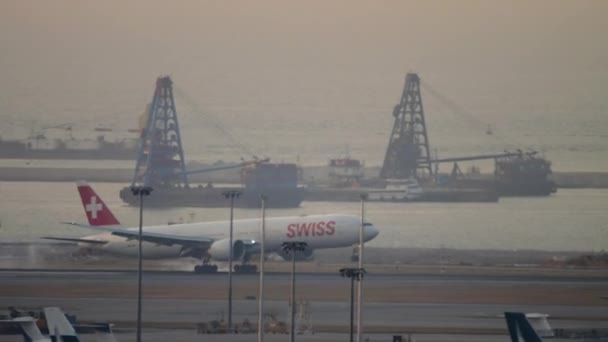 Hong Kong 2019 Swiss着陸のボーイング77は 香港空港の日没で触れ ブレーキをかけ 長いショットサイドビュー Swissはスイス最大の航空会社です — ストック動画