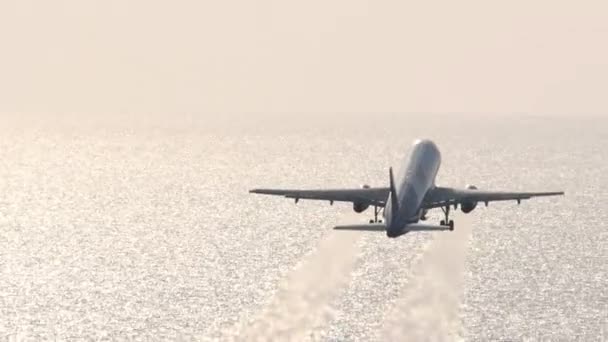 Filmfelvétel Egy Sugárhajtású Gépről Amint Felszáll Ragyogó Tenger Hátterében Repülő — Stock videók