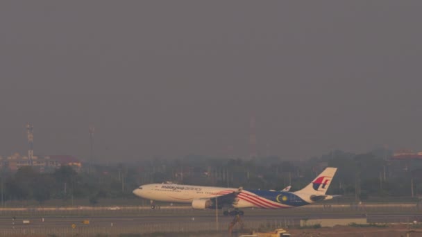 バンコク Thailand 2023 バンコクのスワンナプーム空港で離陸するマレーシア航空のエアバスA330 長いショットサイドビュー 旅客フライト出発 — ストック動画