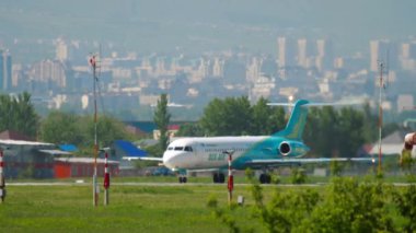 ALMATY, KAZAKHSTAN - 5 Mayıs 2019: Yolcu uçağı Fokker 100, Up-F1005 Bek Air pistte, yan görüş. Uçak kalkıyor.