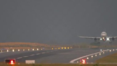 Phuket havaalanı pistine inen yolcular. Uçak iniş takımları piste iniyor. Jet uçağı fren yapıyor, spoiler veriyor.