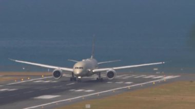 Yolcu geniş gövdeli modern uçak kalkış için hızlanıyor. Denizin arka planına karşı uçak