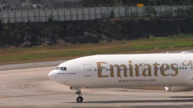 PHUKET, THAILAND - 13 Şubat 2023: Phuket havaalanında taksicilik yapan geniş gövdeli Boeing 777 Emirates uçağı. Jet uçağı geliyor. Turizm ve seyahat kavramı