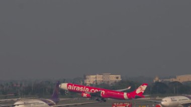 BANGKOK, THAILAND - 01 Mart 2023 Airbus A330 AirAsia yolcu uçağının kalkış görüntüsü, Suvarnabhumi Havaalanı, Bangkok 'a tırmanış, yan görüş, uzak çekim