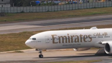 PHUKET, THAILAND - 13 Şubat 2023: Phuket havaalanında taksicilik yapan geniş gövdeli Boeing 777 Emirates uçağı. Jet uçağı geliyor. Turizm ve seyahat kavramı
