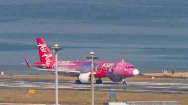 PHUKET, THAILAND - 20 Şubat 2023: Airbus A320, AirAsia A320neo Livery 'den Airbus A320neo, Phuket havaalanında kalkış için piste çıkıyor. Uçak kalkıyor. Deniz kıyısı havaalanı yakınında.