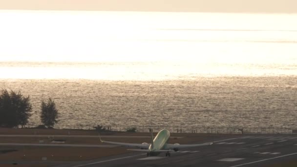 飞机在背光下加速起飞 飞越海面 旅行概念 — 图库视频影像