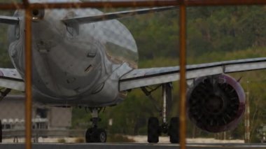 PHUKET, THAILAND - 16 Şubat 2023: Orta atış, Juneyao Airlines 'ın Airbus A320, B-321C' si Phuket havaalanı pistinde, yan görüş. Uçak havalanıyor, kalkıyor, çitten bakıyor.