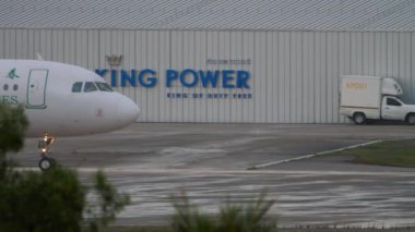 PHUKET, THAILAND - NOVEMBER 28, 2019: Airbus A320-214, B-1628 Spring Airlines, Phuket havaalanında taksicilik, yan görüş. Hava sahası yağmurdan ıslandı.