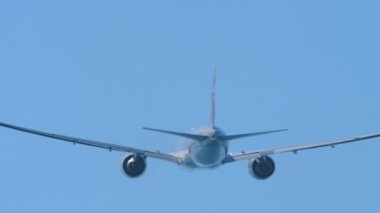 Tanınmayan bir üniforması olan jet uçağı kalkıyor ve tırmanıyor. Mavi gökyüzünde uçak, dikiz manzaralı.
