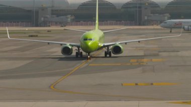 BANGKOK, THAILAND - S7 Airlines 'dan Boeing 737 sefer sayılı yolcu uçağı, Suvarnabhum havaalanı BKK' daki terminale doğru hareket ediyor. Uçak geliyor.