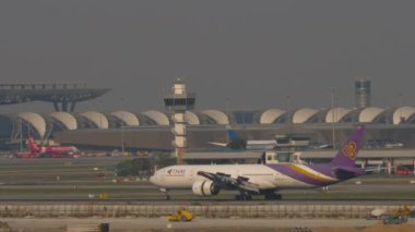 BANGKOK, THAILAND - Mart 01, 2023: Geniş gövdeli Boeing 777, Tayland Havayolları 'ndan HS-TKZ, Suvarnabhumi Havaalanı' na indikten sonra yavaşlıyor, yan görüş. Spoiler verin. Büyük modern yoğun havaalanı