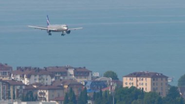 SOCHI, RUSSIA - Ağustos 03, 2022: Aircraft Airbus A320 Aeroflot iniş pisti yaklaşıyor. Yolcu uçağı geliyor. Şehrin üzerinde gökyüzünde bir uçak
