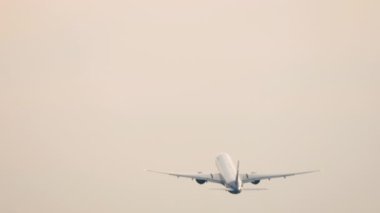 Kalkıştan sonra tanınmaz bir şekilde tırmanan bir jet uçağının arka görüntüsü. Yolcu uçağı kalkıyor. Uçak uçuyor. Seyahat kavramı