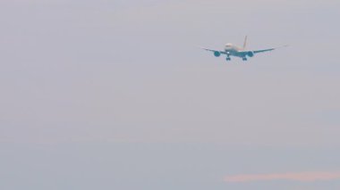 Yolcu jet uçağı inişe geçiyor. Gökyüzünde bir uçak. Uçak uçuşu, uzak çekim, ön manzara.