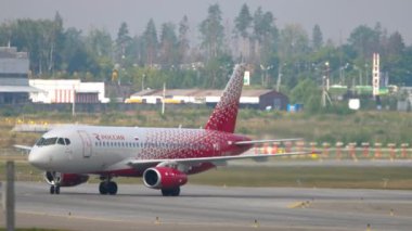 MOSCOW, Rusya Federasyonu - 29 Temmuz 2021: Plane Sukhoi Superjet 100, RA-89047 Rossiya taksisi, yan görüş. Seyahat kavramı