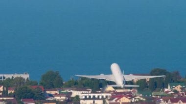 Uçan bir jet yolcu uçağının görüntüsü. Uçak kalkıyor. Ticari uçaklar mavi deniz üzerinden kalkıyor.