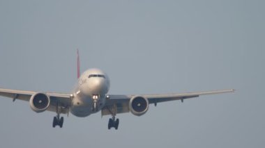PHUKET, THAILAND - 19 Şubat 2023: Boeing 777, RA-73272 Ikar havayolu şirketi Phuket havaalanına iniş yapmak üzere. Uçak uçuyor, iniyor, ön manzara