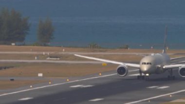 PHUKET, THAILAND - 23 Şubat 2023: Boeing 787 Dreamliner, Etihad Havayolları 'ndan A6-BLU, Phuket Havaalanı' ndan kalkıyor, yan görüş. Uçak pistte, deniz arka planında.