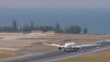 PHUKET, THAILAND - 13 Şubat 2023: Boeing 777 Emirates Phuket havaalanına indikten sonra fren yapıyor. Jet uçağı geliyor. Spoiler verin. Turizm ve seyahat kavramı