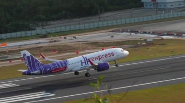PHUKET, THAILAND - 11 Şubat 2023: Airbus A320, HK ekspres iniş pistine B-LCP, Phuket havaalanında iniş ve frenleme, yan görüş. Bir yolcu uçağının görüntüsü geldi.