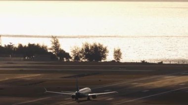 Uçak silueti kalkıştan sonra arka planda, arka planda, uzak planda deniz üzerinden tırmanıyor.