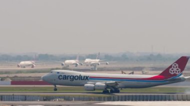 BANGKOK, THAILAND - Mart 01, 2023: Boeing 747, Cargolux LX-VCE Suvarnabhumi Havaalanı pistine iniyor, yan görüş. Kargo jumbo jet freni indikten sonra yavaşlıyor. Spoiler hazır.