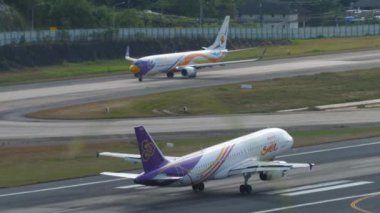 PHUKET, THAILAND - 11 Şubat 2023: Airbus A320, Tayland 'ın HS-TXB' si Phuket havaalanına indikten sonra fren yapıyor, yan görüş. Uçak geliyor.