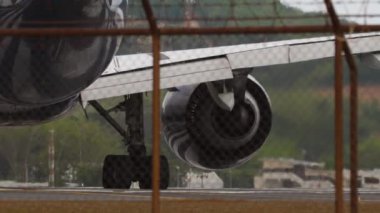 Taksideki yolcu uçağı, piste dönsün. Uçak havaalanında, çitin arkasını görüyor.