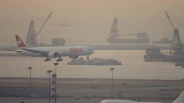 HONG KONG - 07 Kasım 2019: Boeing 777, SWISS inişi, Hong Kong havaalanında piste dokunuyor, uzun menzilli yan görüş. SWISS İsviçre 'nin en büyük havayolu şirketidir.