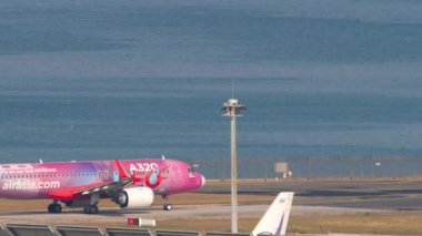 PHUKET, THAILAND - 20 Şubat 2023: Airbus A320, AirAsia A320neo Livery Phuket havaalanı pistinde taksicilik yapıyor. Deniz kıyısı havaalanı yakınında.