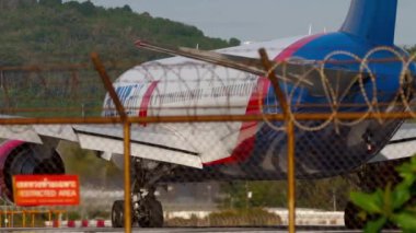 PHUKET, THAILAND - Şubat 04, 2023: Uçak Boeing 767, RA-73034 Azur Air pistte taksicilik yapıyor. Sonra uçuş kesintisi, sağ iniş takımlarının yanması, motor akımı.