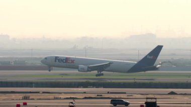 BANGKOK, THAILAND - 01 Mart 2023: Yük uçağı Boeing 767, N107FE FedEx, gün batımında Suvarnabhumi Havaalanı 'na inişe geçiyor.