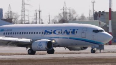 NOVOSIBIRSK, Rusya Federasyonu - 27 Nisan 2024: Boeing 737, UP-B3722 SCAT havayolları Tolmachevo havaalanına varıyor. Haze havaalanında. Uçak fren yapıyor, spoiler veriyor.