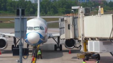 PHUKET, THAILAND - 28 Şubat 2023: Bangkok Air Airbus A320, Phuket havaalanı terminali. Kolu uçağa kenetliyorum. Uçak ve teleskopik iskele