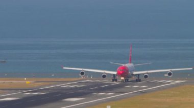 PHUKET, THAILAND - Şubat 06, 2023: Edelweiss Havaalanı pistindeki Airbus A340. Jet uçağı kalkışa hazır. Mavi deniz arka planı. Seyahat kavramı