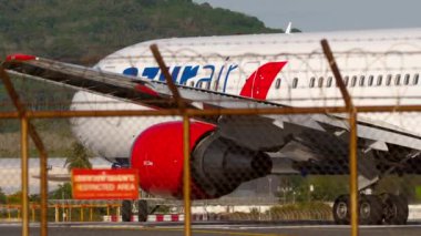 PHUKET, THAILAND - Şubat 04, 2023: Azur Air 'in 767 numaralı uçağı pistte taksicilik yapıyor. Sonra uçuş kesintisi, sağ iniş takımlarının yanması, motor akımı.