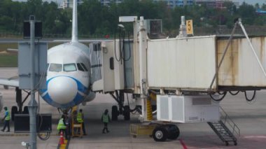 PHUKET, THAILAND - 28 Şubat 2023: Bangkok Air Airbus A320, Phuket havaalanı terminali. Teleskopik merdiven bir uçakla kenetleniyor. Uçuştan önce uçak.