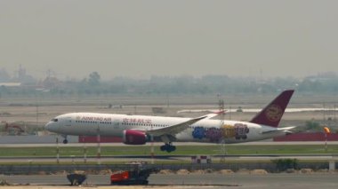 BANGKOK, THAILAND - Mart 01, 2023: Boeing 787 Dreamliner, AB-209R Juneyao Air Genshin Livery uçağı Swarnabhumi havaalanı BKK 'ya indikten sonra fren yapıyor. Spoiler hazır.
