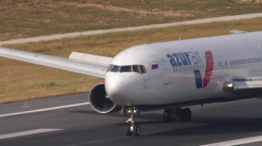PHUKET, THAILAND - 13 Şubat 2023: Boeing 767, RA-73078 Azur Air uçağı Phuket havaalanına indikten sonra fren yapıyor. Seyahat kavramı