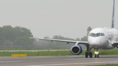 ALMATY, KAZAKHSTAN - 12 Mayıs 2024: Yakutia Havayollarında taksicilik yapan uçak Sukhoi Superjet 100. Yolcu uçağı taksi yolunda.