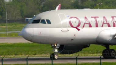 ALMATY, KAZAKHSTAN - 10 Mayıs 2024: Yolcu jeti Airbus A320, Katar Havayolları A7-LAE Almaty havaalanında taksicilik. Taksideki uçak, yan görüş.