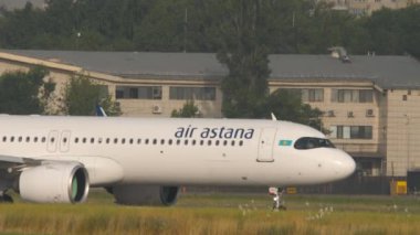 ALMATY, KAZAKHSTAN - 27 Temmuz 2024: Airrier Airbus A321, Air Astana 'nın El-KDG' si Almaty havaalanı taksisinde, yan görüş. Seyahat kavramı