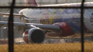 PHUKET, THAILAND - 19 Şubat 2023: Phuket Havaalanı 'nda İnanılmaz Yeni Bölümler Livery taksisi yapan AirAsia uçağı. Asya 'da düşük maliyetli. Uçak pistte kaldı. Taksideki uçak.