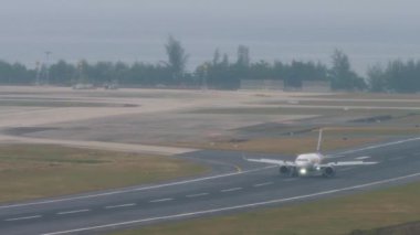 PHUKET, THAILAND - FEBRUARY 03, 2023: Airbus A320, HK ekspres iniş Phuket havaalanına. Yolcu uçağı yavaşlıyor, fren yapıyor, spoiler veriyor.