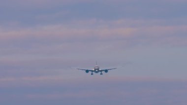 Yolcu uçağı inişe geçiyor. Gökyüzünde ticari uçak, ön manzara.